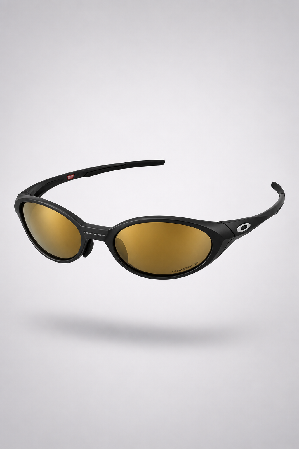 Oakley Eye Jacket Y2K — Matte Black / Gold Mirror sunglasses, front three-quarter view on a light gray studio background